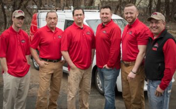 a group of rainbow pest technicians standing in a line in front of vehicle