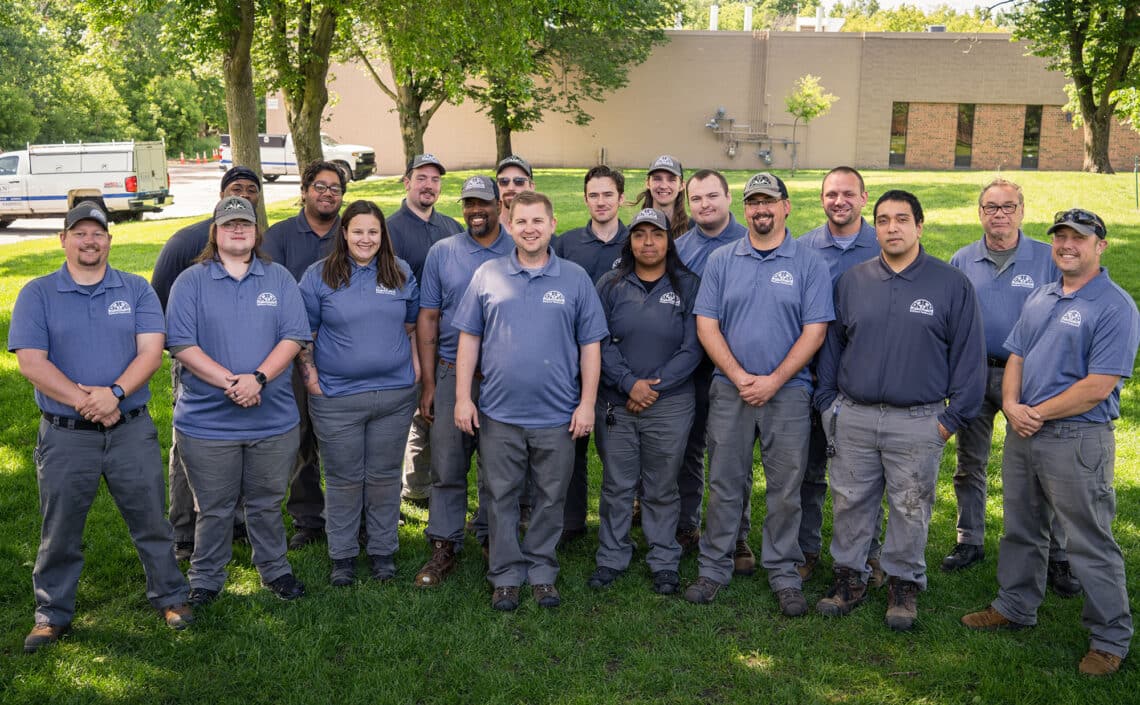 a group of rainbow pest technicians standing in a line in front of vehicle