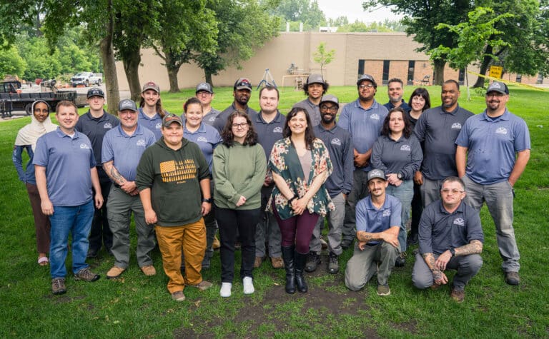 a group of Rainbow Pest Experts technicians standing in a line in front of vehicle